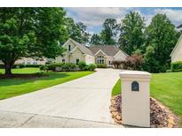 Well-maintained one story home boasting lush landscaping, a long driveway, and craftsman architectural details at 1275 Kelly Nelson Dr, Lawrenceville, GA 30043