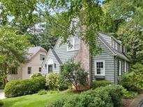 Charming home with a brick chimney and lots of surrounding mature landscaping at 2054 Palifox Ne Dr, Atlanta, GA 30307