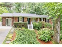 Charming brick home with mature landscaping, black shutters, and a welcoming front porch at 2197 Fairway Ne Cir, Brookhaven, GA 30319