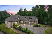 Beautiful brick home featuring manicured landscaping, three-car garage, basketball court, and brick and stone accents at 241 Russell Rd, Lawrenceville, GA 30043