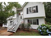 Charming two-story home featuring a welcoming front porch and beautifully landscaped yard with vibrant flowers at 236 Hiram Sudie Rd, Dallas, GA 30157