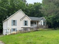 Charming home featuring light siding, light shutters, lush greenery, and a convenient ramp to the front door at 134 Summer Lake Dr, Dallas, GA 30157