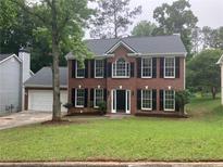 Charming two-story brick home with black shutters and a well-maintained front yard at 7593 Watson Bay Ct, Stone Mountain, GA 30087