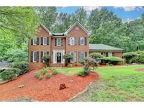 Charming brick two-story home with a landscaped front yard and black shutters at 2530 Ashbourne Dr, Lawrenceville, GA 30043