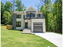 Modern two-story home with a balcony, attached garage, and well-manicured lawn at 4366 Bradley Sw Dr, Snellville, GA 30039