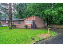 Charming single-story brick home featuring a lush green lawn and inviting front entrance at 2046 Rector Sw Dr, Atlanta, GA 30311