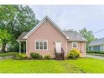 Charming one-story home with light pink siding, stone accents, and a well-manicured green lawn at 2378 Randall Ave, Lithonia, GA 30058