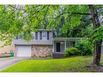Charming split-level home with a stone facade, attached garage, and a well-manicured lawn at 4766 White Oak Path, Stone Mountain, GA 30088