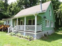 Charming log cabin with a cozy front porch and well-maintained lawn at 3096 Campground Rd, Winston, GA 30187
