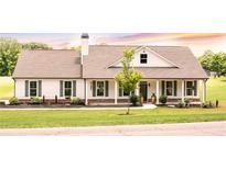 Charming single-story home featuring a covered porch, gray shutters, and a beautifully landscaped yard at 2980 Hd Atha Rd, Covington, GA 30014