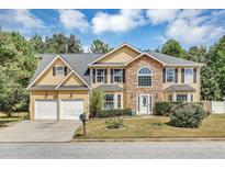 Inviting two-story home featuring stone accents, a two-car garage, and well-manicured landscaping at 5115 Estonian Dr, Fairburn, GA 30213