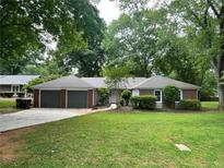 Charming single story brick home with a two-car garage and a well-manicured front yard at 215 Truehedge Trce, Roswell, GA 30076