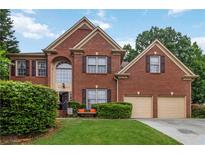 Charming two-story brick home with a well-manicured lawn and inviting curb appeal at 3780 Summit Gate Dr, Suwanee, GA 30024