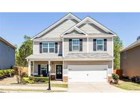 Charming two-story home featuring neutral siding, black shutters, and a well-manicured front lawn at 327 Nobleman Way, Canton, GA 30114