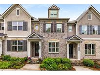 Beautiful townhome with gray brick, shuttered windows and landscaped flower beds at 1661 Hammock Dr, Smyrna, GA 30080