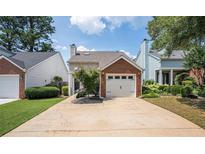 Charming home with a brick-accented garage and well-manicured lawn at 1822 Commonwealth Dr, Woodstock, GA 30188