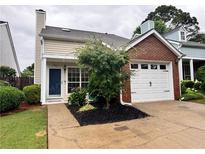 Charming townhouse with a one-car garage, well-maintained lawn, and inviting curb appeal at 1822 Commonwealth Dr, Woodstock, GA 30188