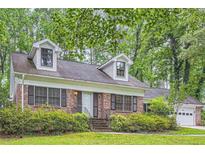 Charming brick home with dormer windows, black shutters, and lush landscaping at 421 Fond Du Lac Dr, Stone Mountain, GA 30088