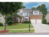 Charming two-story home with brick and siding, a well-manicured lawn and a two-car garage at 1547 Trilogy Park, Hoschton, GA 30548