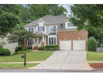 Charming home with a well-manicured lawn, two-car garage, and welcoming front porch at 1547 Trilogy Park, Hoschton, GA 30548