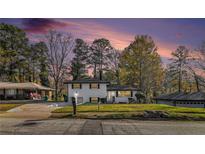 Charming home featuring a manicured lawn, and beautiful contrasting black shutters, all set under a picturesque twilight sky at 2178 Shamrock Dr, Decatur, GA 30032