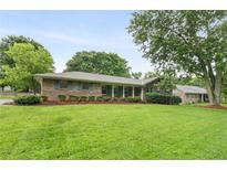Charming brick home featuring a large front yard with mature trees and manicured shrubs at 2644 Hickory Valley Dr, Snellville, GA 30078