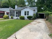 Charming bungalow with screened porch, lush front lawn, and convenient covered carport at 1829 Mercer Ave., College Park, GA 30337