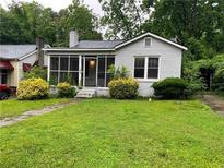 Charming bungalow featuring a screened porch and lush landscaping enhancing curb appeal at 1829 Mercer, College Park, GA 30152