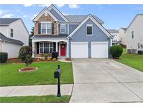 Charming two-story home featuring a red front door, two-car garage, and well-manicured lawn at 2530 Vistoria Dr, Cumming, GA 30041