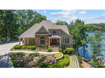 Charming stone and shake home with manicured landscaping and lake view at 7815 Bamby Rd, Cumming, GA 30041
