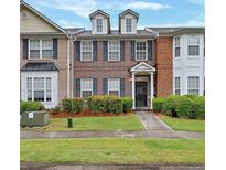 Charming brick townhome with manicured lawn and traditional architectural details at 4713 Liberty Square Dr, Acworth, GA 30101