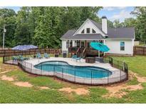 Backyard features a kidney-shaped pool, lounge chairs, and a covered deck at 5745 Westwood Dr, Cumming, GA 30040