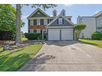 Charming two-story home with well-maintained lawn and a two-car garage at 1003 Dunedin Trl, Woodstock, GA 30188