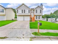 Charming two-story home featuring a two-car garage and a well-manicured lawn at 2535 Brookgate Xing, Ellenwood, GA 30294