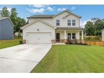 Charming two-story home featuring a two-car garage, covered porch with rocking chairs, and a well-manicured front lawn at 16 Dovecrest Way, Acworth, GA 30101