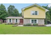 Charming two-story home with a brick facade and a well-manicured front lawn at 2201 Colonial Oak Way, Stone Mountain, GA 30087