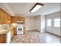 Charming kitchen featuring wood cabinets, white appliances, and an adjacent dining area with a double door exit at 259 Hwy 11, Social Circle, GA 30025