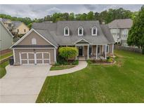 Charming home features a two-car garage and a well-manicured front lawn and an inviting front porch at 4721 W Lakeshore Dr, Acworth, GA 30101