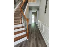Inviting entryway with wood-look floors, stairs and decorative wood trim at 5580 Jamerson Dr, Atlanta, GA 30349