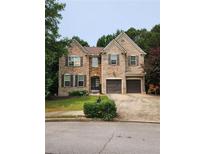 Charming two-story brick home featuring a two-car garage and well-manicured lawn and landscaping at 5580 Jamerson Dr, Atlanta, GA 30349
