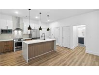 Modern kitchen features stainless steel appliances, an island with a breakfast bar, and stylish pendant lighting at 112 Rogers Ne St # 304, Atlanta, GA 30317