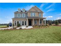 Charming two-story home featuring a mix of brick and blue siding, complemented by a well-manicured lawn at 352 Foxglove Way, Mcdonough, GA 30253