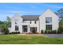 A bright, two-story home featuring a black roof and well-manicured lawn and landscaped grounds at 530 Old Cobblestone Dr, Atlanta, GA 30350