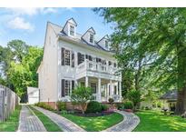 Charming two-story home with a landscaped yard, brick accents, and a double-decker porch with white columns and shutters at 1070 Standard Ne Dr, Brookhaven, GA 30319