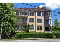 Modern condo building featuring balconies, awnings, and a landscaped front yard at 281 15Th Ne St # 202, Atlanta, GA 30309