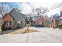 Charming home boasts brick and siding exterior, well-manicured landscaping, and a spacious driveway at 1765 Dew Pl, Marietta, GA 30064