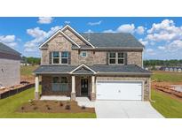 Beautiful brick home with a two car garage and well manicured front yard at 113 Canal St, Hampton, GA 30228