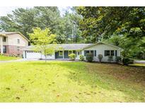 Charming single-story home with a well-manicured lawn and mature trees enhancing curb appeal at 2519 Lauderdale Ne Dr, Atlanta, GA 30345