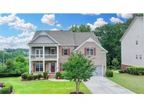 Beautiful two-story brick home with a well-manicured lawn, a front porch, and a driveway at 5770 Bridleton Xing, Suwanee, GA 30024