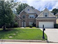 Charming two-story brick home with a well-manicured lawn and attached two car garage at 458 Vinings Vintage Cir, Mableton, GA 30126